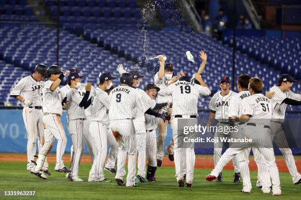 Takuya Kai of Team Japan celebrates with his teammates after hitting a game-winning single in the tenth inning to defeat Team United States 7-6...