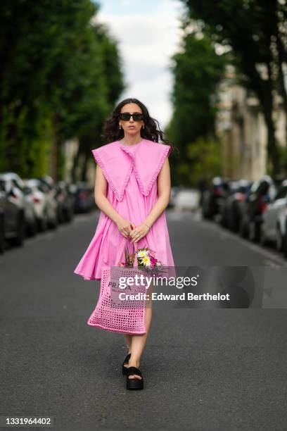 Gabriella Berdugo wears brown square sunglasses Valentino, a pink pleated / gathered dress with maxi Peter Pan ruffled collar from Filkk, a pink...