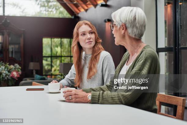 自宅�で高齢の母親とコーヒーを飲む若い女性のショット - woman silver hair young ストックフォトと画像