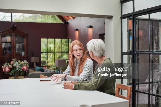 colpo di una giovane donna che sta facendo un caffè con l'anziana madre a casa - granddaughter foto e immagini stock
