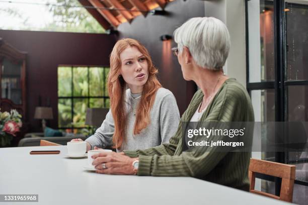 plan d’une jeune femme qui a pris un café avec sa mère âgée à la maison - enfant adulte photos et images de collection