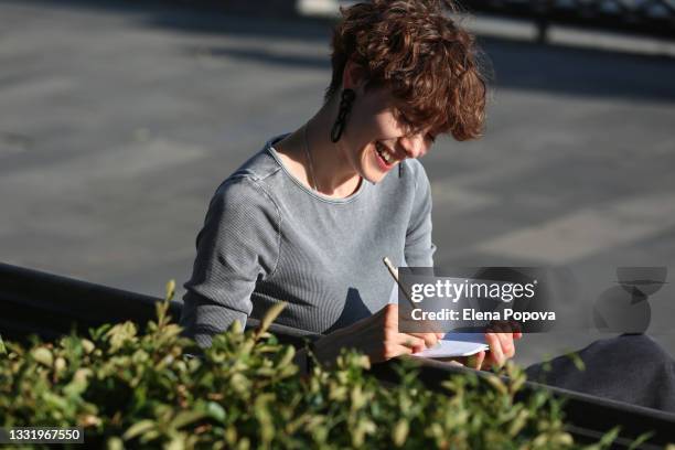 portrait of young confidence woman making  sketches at the public park - bank student stock-fotos und bilder