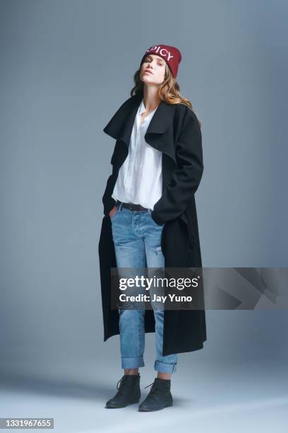 foto de una joven posando sobre un fondo gris - abrigo gris fotografías e imágenes de stock