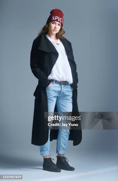 shot of a young woman posing against a grey background - women standing against grey background stock pictures, royalty-free photos & images