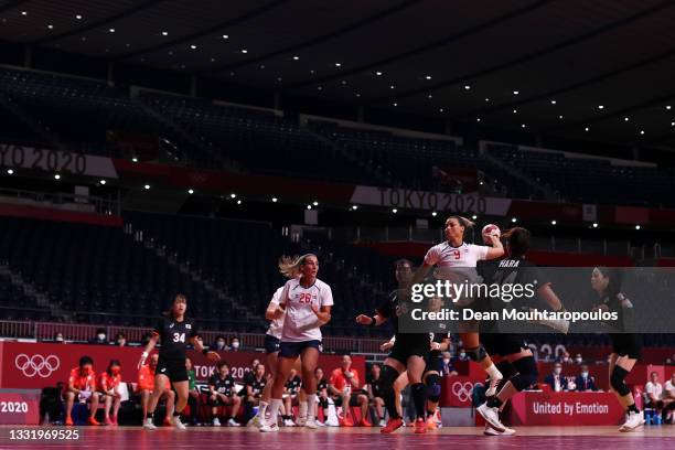 Nora Moerk of Team Norway shoots at goal as Shiori Nagata and Nozomi Hara of Team Japan look on during the Women's Preliminary Round Group A handball...