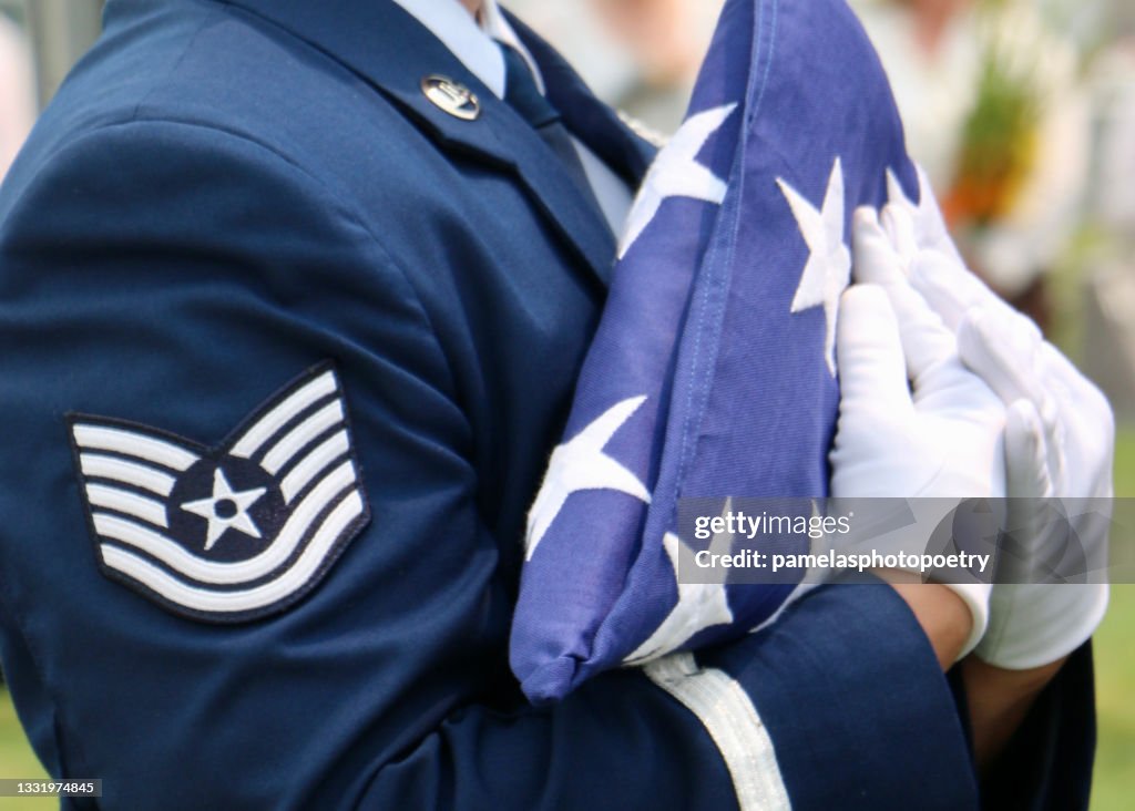 US Air Force Honor Guardsman carrying folded American flag