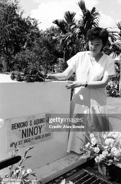 Philippine presidential candidate Corazon Aquino visits Manila Memorial Park cemetery to place flowers on the grave of her husband Benigno 'Ninoy'...