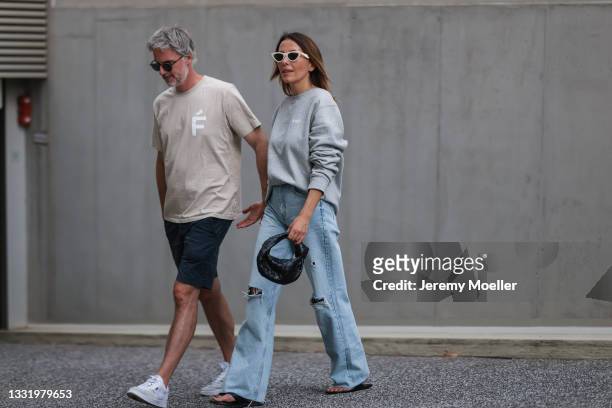 Sebastian Seitz wearing AMF beige shirt and Elise Seitz wearing AMF grey sweater, Zara wide leg pants and Bottega Veneta black bag on July 30, 2021...