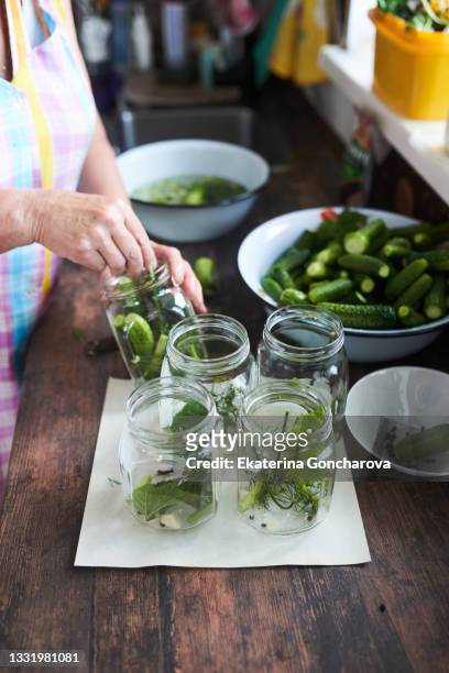 a woman at home makes pickles from cucumbers. - pickle jar stockfoto's en -beelden