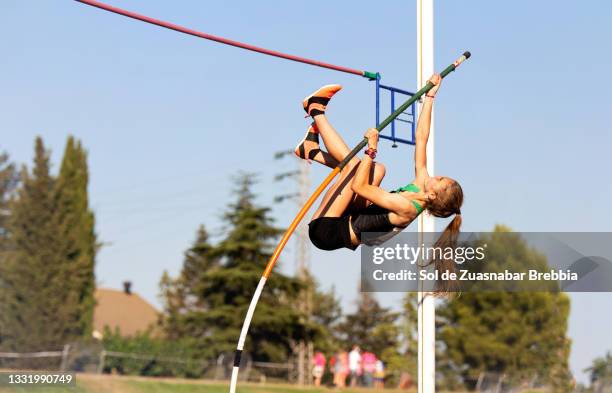 preteen girl practicing pole vault on a running track - mens pole vault stockfoto's en -beelden