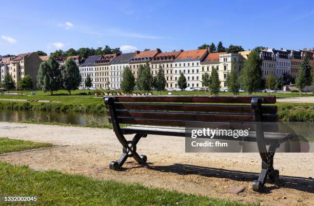 bench with view to görlitz residential buildings (zgorzelec, poland) - riverbank stock-fotos und bilder