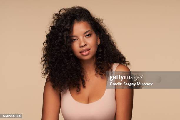 portrait of beautiful mixed race woman on beige background - toma mediana fotografías e imágenes de stock