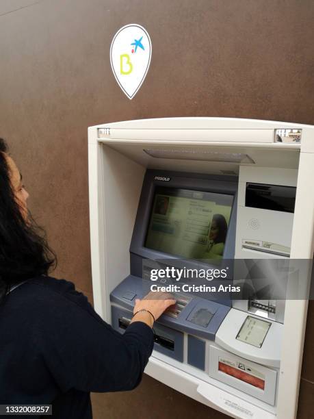 Woman in an ATM of Caixa Bank Bankia on June 5, 2021 in Madrid, Spain.