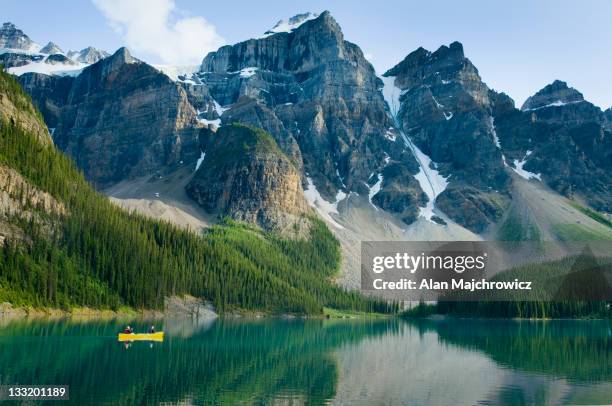 canoeists paddling on moraine lake with the wenkch - canadese rocky mountains stockfoto's en -beelden