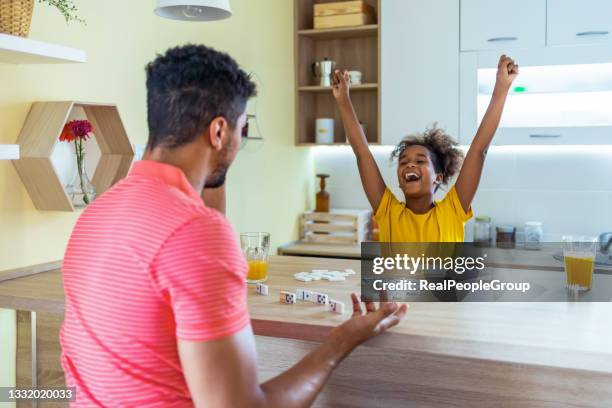 father and daughter playing dominoes at home. - game night stock pictures, royalty-free photos & images