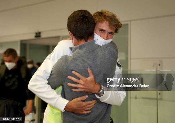 German tennis player and Tokyo 2020 gold medalist Alexander Zverev is hugged by his brother Mischa Zverev after his arrival at Airport Munich on...