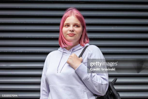 ritratto all'aperto di una donna di 20 anni con una camicia con cappuccio viola con i capelli rosa - 22 year old foto e immagini stock