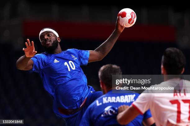 Dika Mem of Team France shoots at goal as Luka Karabatic of Team France and Merza Ali Ali of Team Bahrain look on during the Men's Quarterfinal...