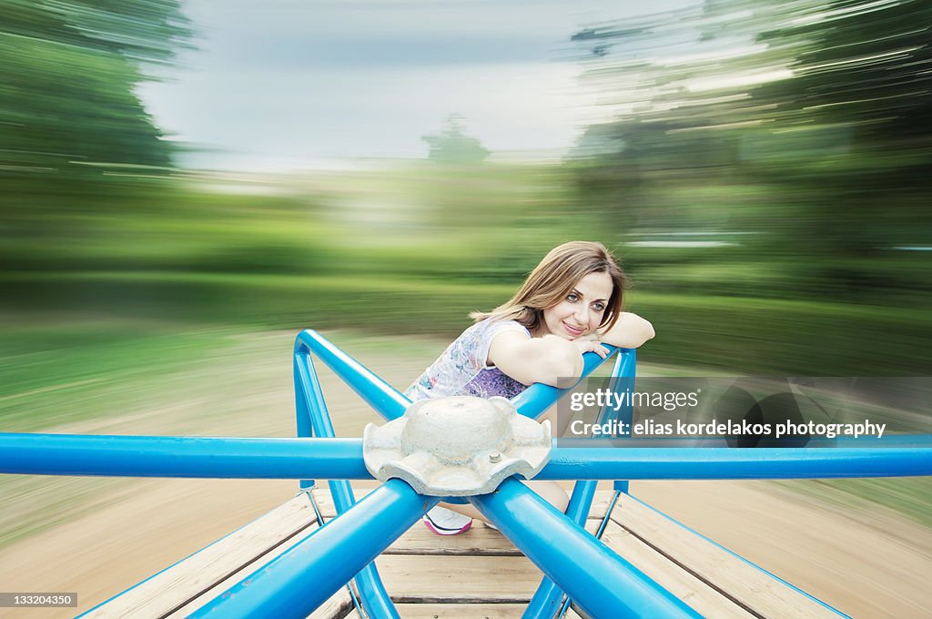 Girl sitting on merry go round