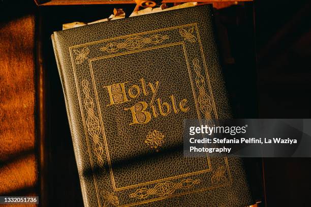 holy bible on a wooden table under dusk sun light - old book 個照片及圖片檔