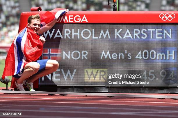 Karsten Warholm of Team Norway poses with a scoreboard showing his new world record time after winning the gold medal in the Men's 400m Hurdles Final...