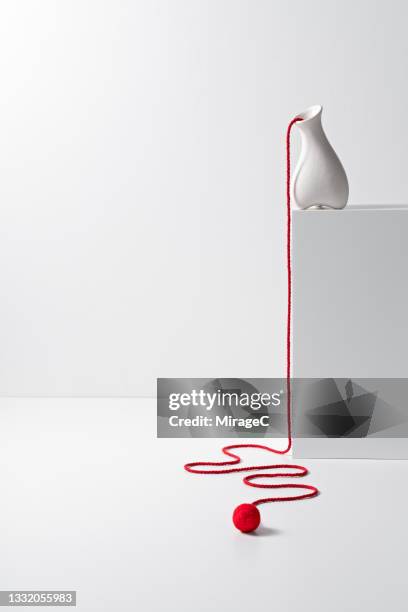 long and curved rope falling from white vase - degeneration stock pictures, royalty-free photos & images