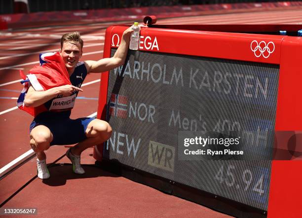 Karsten Warholm of Team Norway poses with a scoreboard showing his new world record time after winning the gold medal in the Men's 400m Hurdles Final...