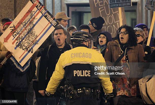 Police hold back demonstrators from Occupy Chicago and Stand Up Chicago as they protest outside the Chicago Board of Trade Building November 17, 2011...