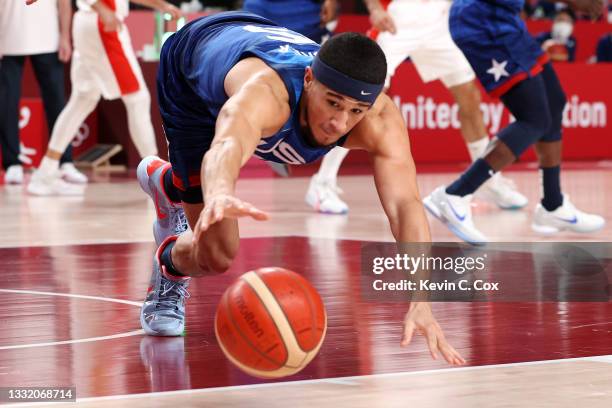 Devin Booker of Team United States reaches for a loose ball against Team Spain during the second half of a Men's Basketball Quarterfinal game on day...