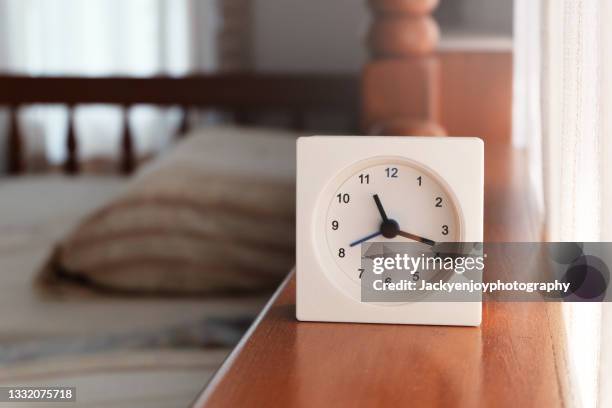 close-up of alarm clock on bed at home - alarm clock close up stock pictures, royalty-free photos & images