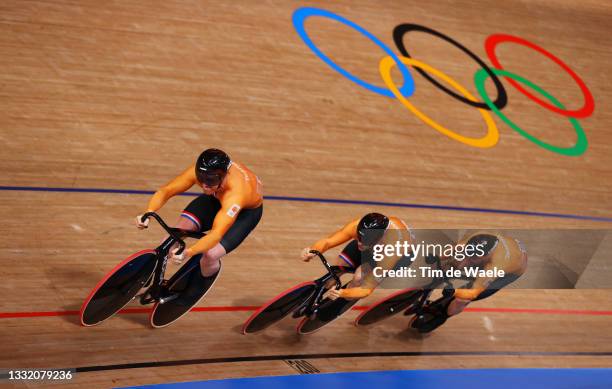 Roy van den Berg, Harrie Lavreysen and Matthijs Buchli of Team Netherlands sprint to setting a new Olympic record ahead of Team Australia during the...