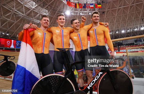 Roy van den Berg, Jeffrey Hoogland, Harrie Lavreysen and Matthijs Buchli of Team Netherlands celebrate winning a gold medal and setting a new Olympic...