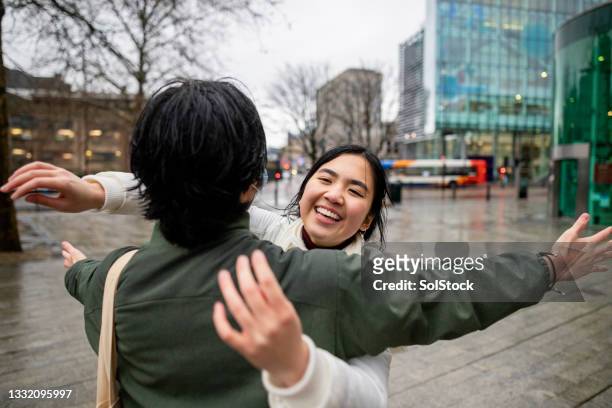 junges paar wieder vereint - young asian friends hugging stock-fotos und bilder