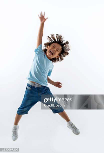 kleiner junge springt auf weißem hintergrund - kid jumping stock-fotos und bilder