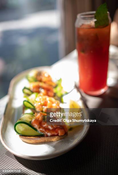 bruschetta with fresh cucumber and salmon tartare on a plate - filet americain stockfoto's en -beelden