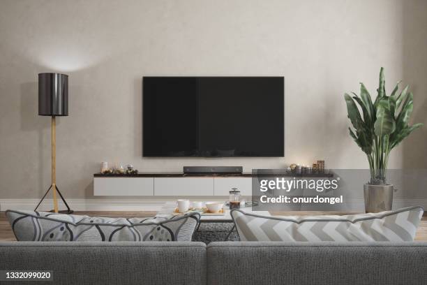 modern living room interior with smart tv, sofa, floor lamp and potted plant - home cinema stockfoto's en -beelden