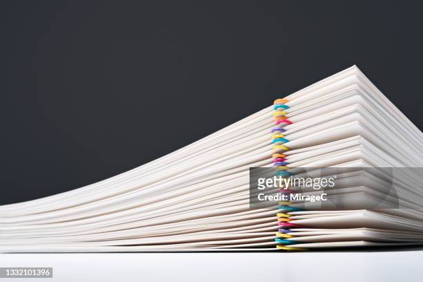stacked paper files with colorful paper clips - documentazione foto e immagini stock