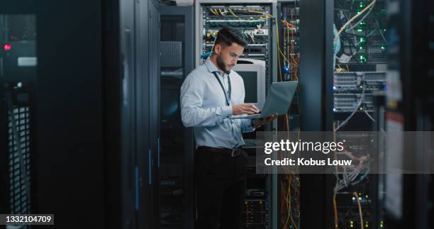 plan d’un jeune ingénieur utilisant son ordinateur portable dans une salle de serveurs - computer network photos et images de collection