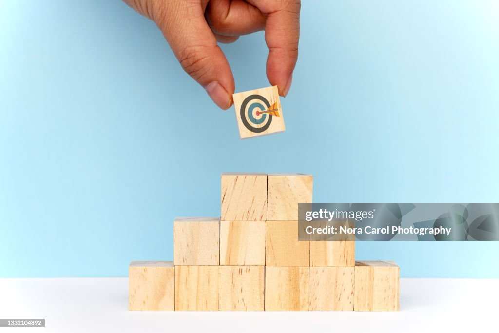 Hand Choosing Target on Top on Wood Toy Block Pyramid