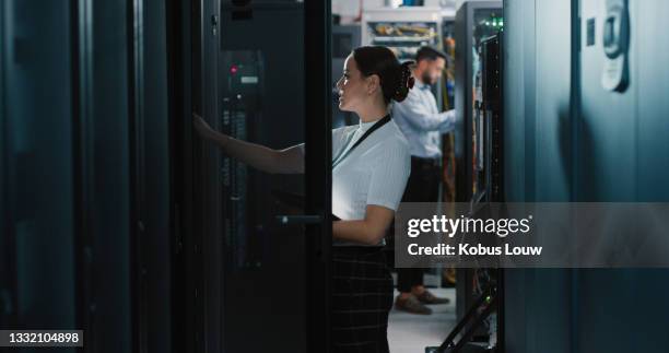 scatto di due colleghi che lavorano insieme in una sala server - data center foto e immagini stock