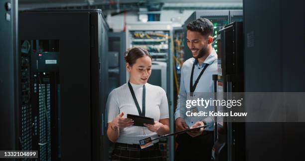 aufnahme von zwei kollegen, die in einem serverraum zusammenarbeiten - server stock-fotos und bilder