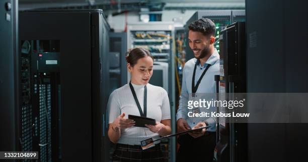 scatto di due colleghi che lavorano insieme in una sala server - networking people foto e immagini stock