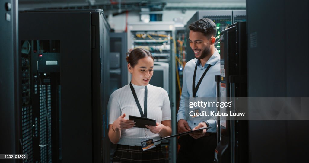 Shot of two colleagues working together in a server room