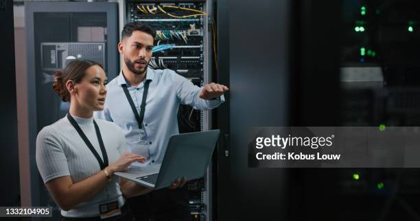 scatto di due colleghi che lavorano insieme in una sala server - computer software foto e immagini stock