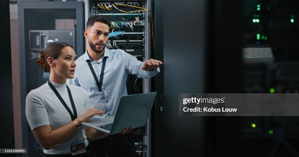 Shot of two colleagues working together in a server room