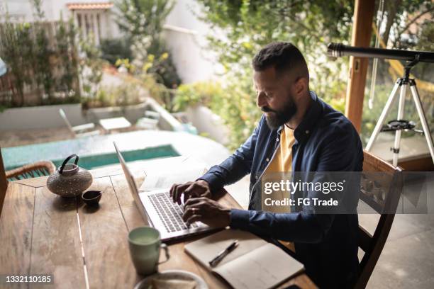 mature man using laptop working at home - real businessman isolated no smile stock pictures, royalty-free photos & images