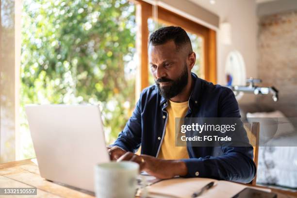 mature man using laptop working at home - real businessman isolated no smile stock pictures, royalty-free photos & images