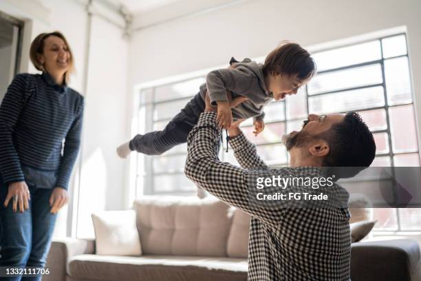 padres jugando con un hijo con necesidades especiales en casa - familia en casa fotografías e imágenes de stock