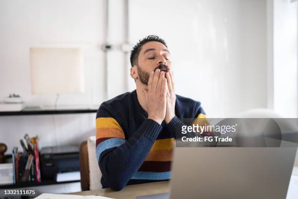 hombre maduro preocupado y cansado usando la computadora portátil que trabaja en casa - man looking upset fotografías e imágenes de stock