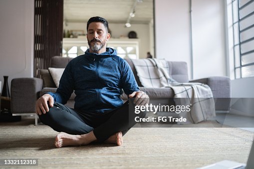 Mature man meditating at home Mature man meditating at home